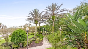 A landscaped garden with palm trees, a winding path, and a well-maintained lawn.