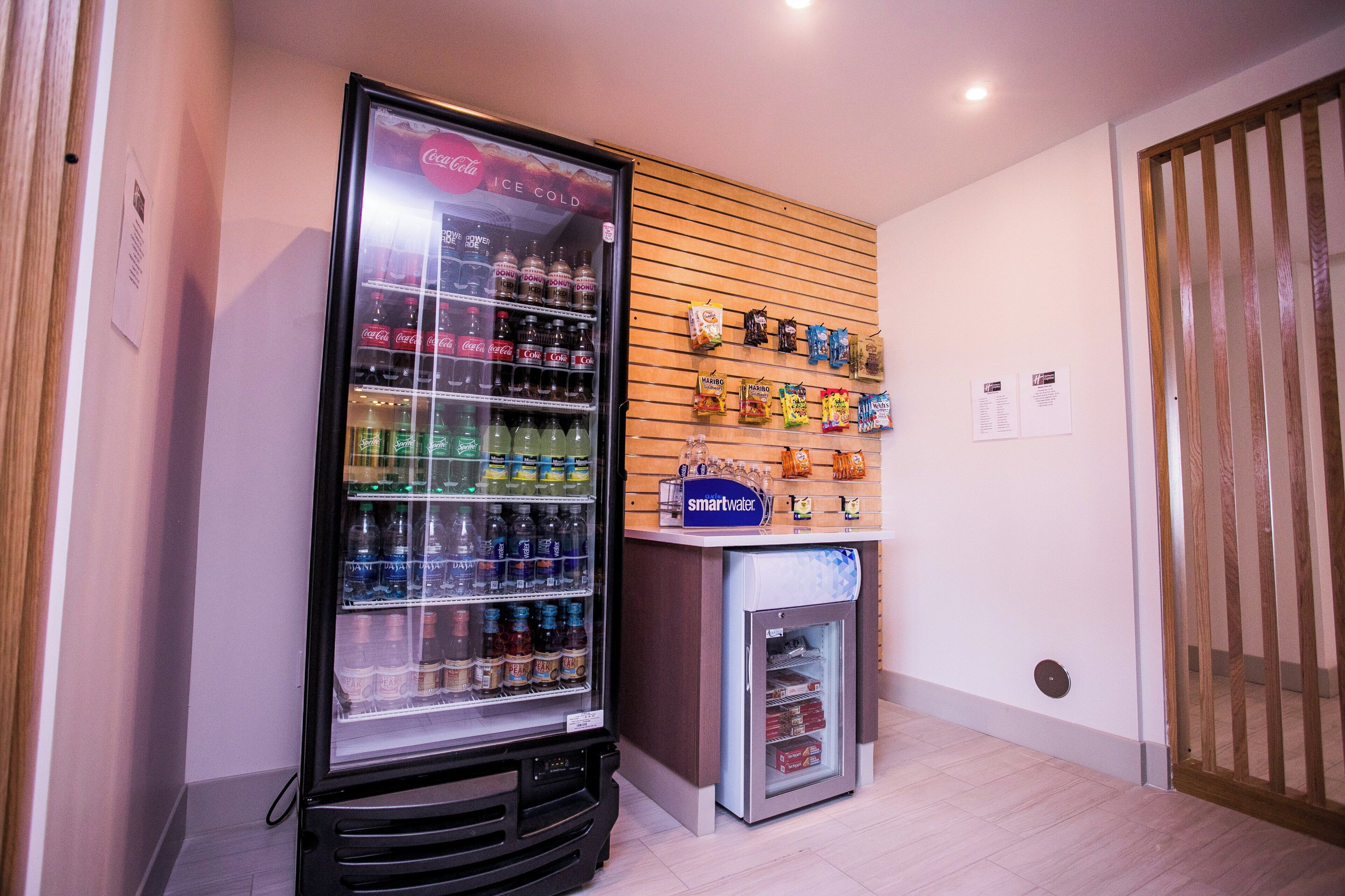 A vending machine area with a refrigerator stocked with beverages and snacks.
