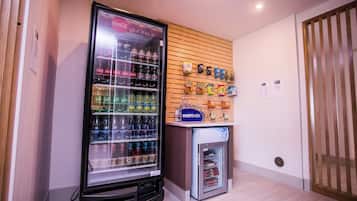 A vending machine area with a refrigerator stocked with beverages and snacks.