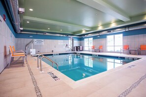 An indoor swimming pool with clear lane markings, safety signs, and a lifeguard chair. - Holiday Inn Express & Suites Rehoboth Beach by IHG (Rehoboth Beach)