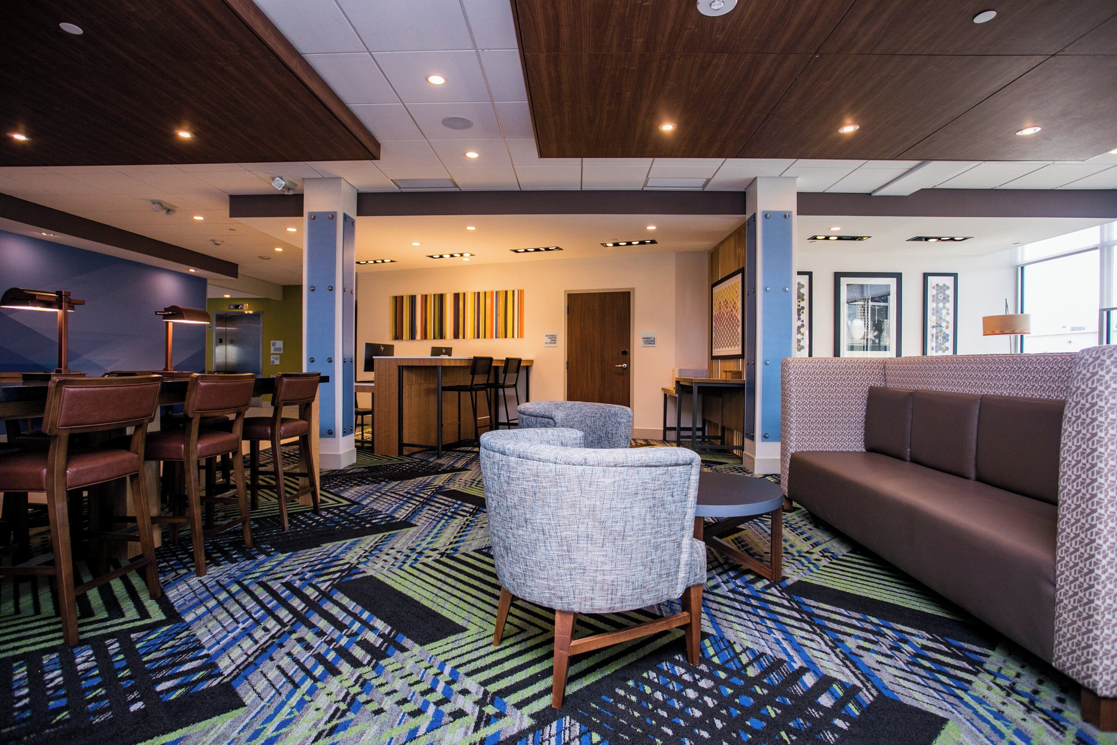 A hotel lobby with a seating area, a bar, and a reception desk.