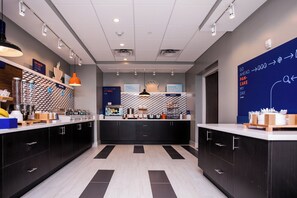 A modern kitchen area with a central island, black cabinets, and a patterned backsplash. - Holiday Inn Express & Suites Rehoboth Beach by IHG (Rehoboth Beach)