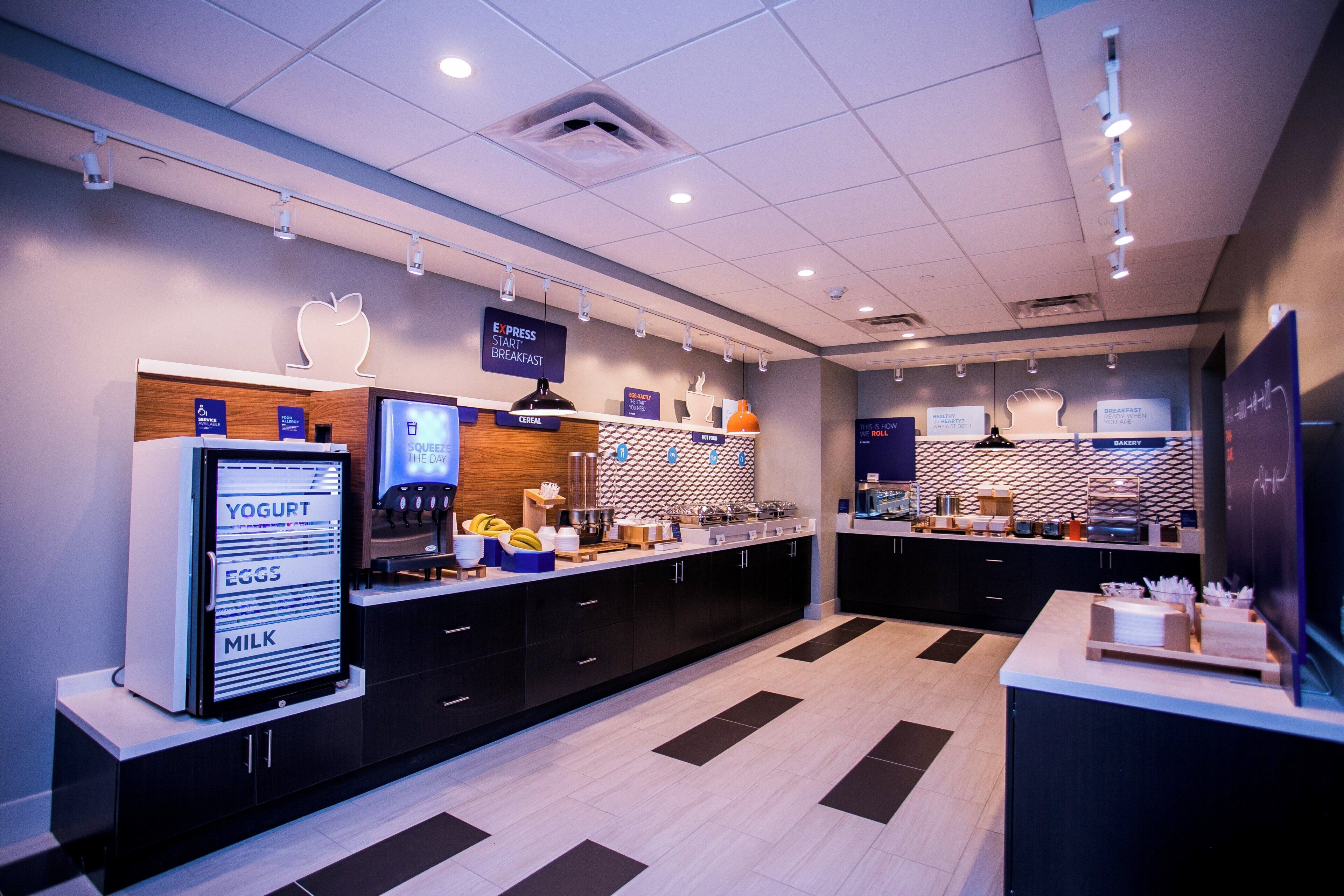 A modern breakfast area with a self-serve station, including yogurt, eggs, and milk.