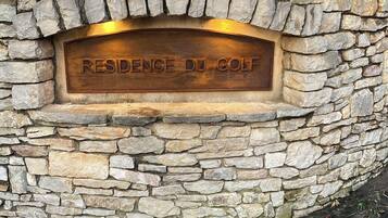 Un muro de piedra con una placa que dice "RESIDENCE DU GOLF".