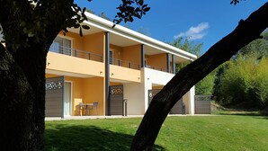 A two-story building with balconies, a covered outdoor seating area, and a well-maintained lawn. - Golf & Résidence de Nîmes Vacquerolles (Nîmes)