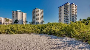 Ein Strandhotel mit mehreren Hochhäusern, Sandstrand und üppiger Vegetation.