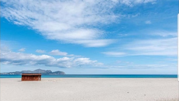 A beach with a wooden structure, clear sky, and distant mountains. - Ronda Playa, apartment with pool just a step away from the sea. (Can Picafort)
