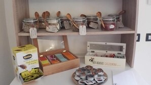 A kitchen counter with storage jars, a box of Mielizia honey, and a plate of snacks. - B&B Guglielmina (Quarna Sotto)