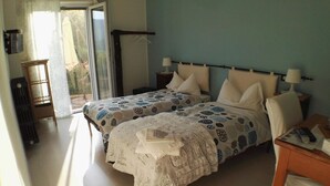 A bedroom with two beds, a small table, and a chair. - B&B Guglielmina (Quarna Sotto)