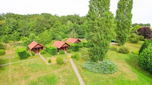 A lodge with multiple cabins, surrounded by lush greenery and a well-maintained lawn.