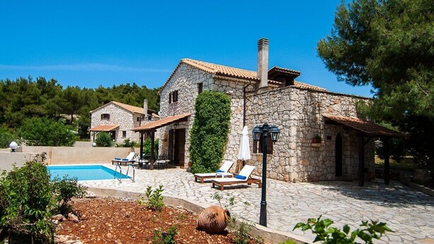 A stone villa with a swimming pool, lounge chairs, and a stone pathway. - Boschetto Holiday Village (Zakynthos)