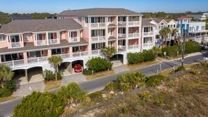 A multi-story hotel with balconies, a covered parking area, and a view of the surrounding landscape. - Oceanfront Condo w/ Dual Balconies + Walk to Folly Pier (Folly Beach)