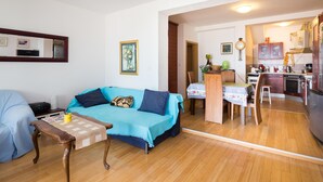Una sala de estar con sofá, una mesita de centro y un comedor con mesa y sillas.