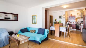 Una sala de estar con sofá, una mesita de centro y un comedor con mesa y sillas.