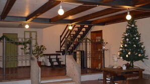 A staircase leading to a second floor with a wooden railing and a Christmas tree decorated with lights and ornaments. - Agriturismo Cipolli e Podò Corte Carlini (Mantua)