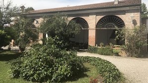A building with arched windows and a brick facade. - Agriturismo Cipolli e Podò Corte Carlini (Mantua)