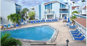 Relax by the pool surrounded by lounge chairs and umbrellas.