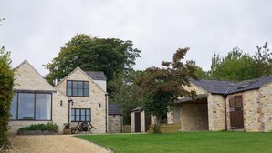 A stone house with a gravel driveway and a well-maintained lawn. - The Retreat (Stroud)