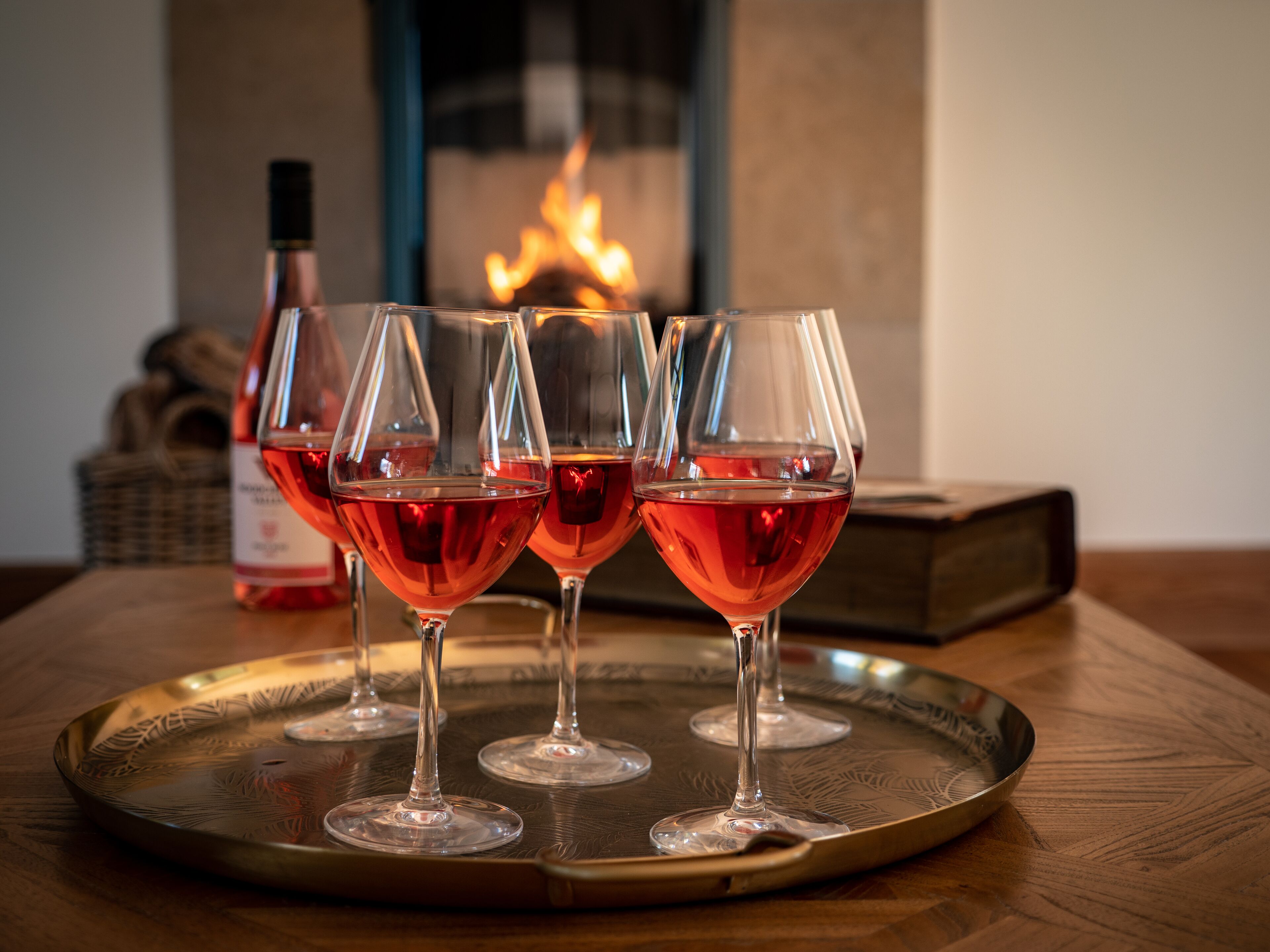 Four wine glasses filled with red wine on a tray.