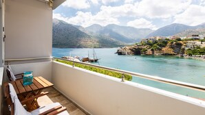 A balcony with a view of a lake, boats, and mountains. - Ocean Dream Suite (Mylopotamos)