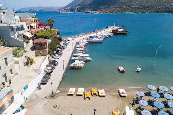 A coastal town with a marina, beach, and buildings including a hotel named "Golden Bee".