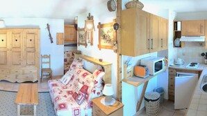 A compact kitchen with wooden cabinets, a microwave, a toaster, and a small sink. - Accommodation at the foot of the ski slopes (La Giettaz)