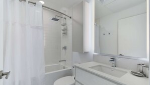 Une salle de bain moderne équipée d’une douche, de toilettes et d’un meuble-lavabo.