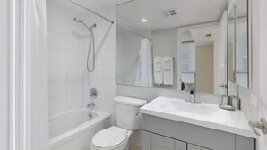 Une salle de bain moderne équipée d’une baignoire, de toilettes et d’un lavabo.