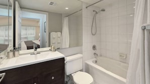 Une salle de bain moderne avec une baignoire, des toilettes et un grand miroir.