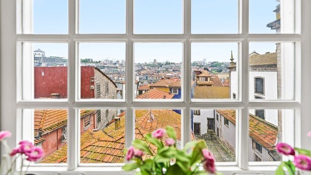 A window with a view of a cityscape through a grid of panes. - GuestReady - Ribeira retreat in Porto centre (Porto)