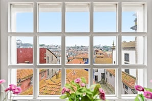 A window with a view of a cityscape through a grid of panes.