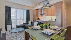 Un appartement moderne comprenant un coin repas, une cuisine et un salon.