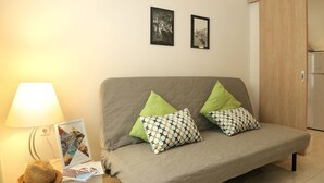 A cozy living room with a grey sofa, two patterned pillows, a lamp, and a framed photo on the wall. - Stylish Modern Apartment (Thessaloniki)