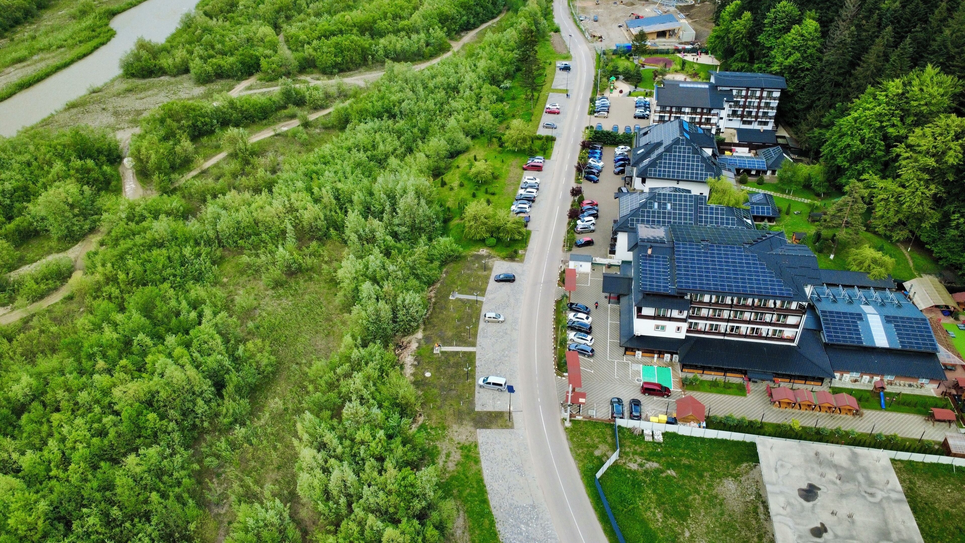 Vue aérienne d’un quartier résidentiel avec de nombreuses maisons, une route et des voitures garées.