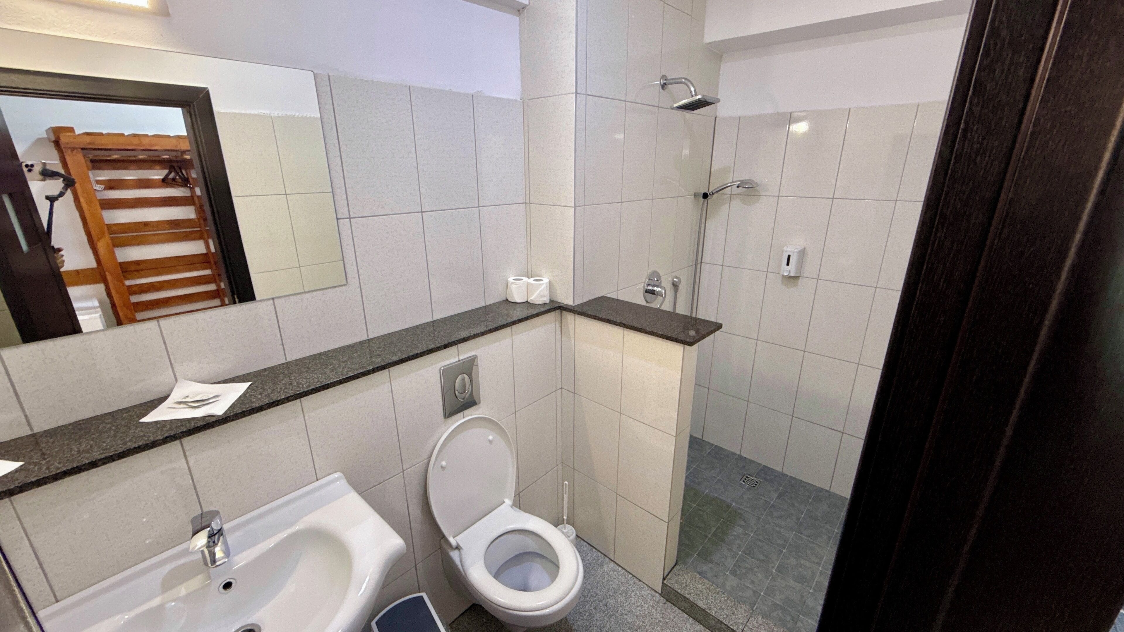A bathroom with a toilet, sink, and shower.