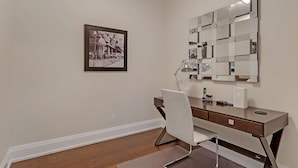 A modern bathroom with a vanity, a mirror, and a framed picture on the wall.