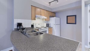 Eine moderne Küche mit Granit-Arbeitsplatten, Edelstahlgeräten und Holzschränken.