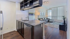 Una cocina moderna con una isla central, electrodomésticos integrados y una zona de comedor con sofá y mesa.