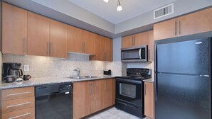 A modern kitchen with wooden cabinets, a stainless steel refrigerator, a microwave, a stove, and a dishwasher. - 2 Bedroom/2 Bathroom Suite (Etobicoke)