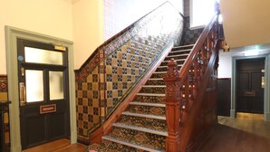 A staircase with ornate wooden railings and patterned carpet. - The Bridge Hotel (Bolton)