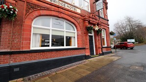 The Bridge Hotel with a brick facade, large arched windows, and a sign above the entrance. - The Bridge Hotel (Bolton)