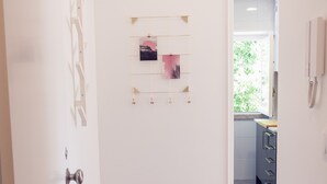 A hallway with wooden flooring, a white door, and a small art piece on the wall. - Bairro Conqvistador Apartment 4 (Lisboa)