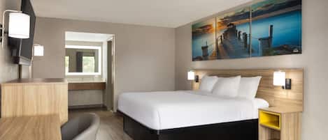 A hotel room with a bed, bedside tables, a desk, and a chair.