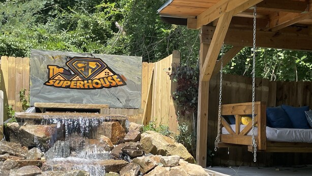 Un pont de fusta amb un cartell que diu "The Superhouse".