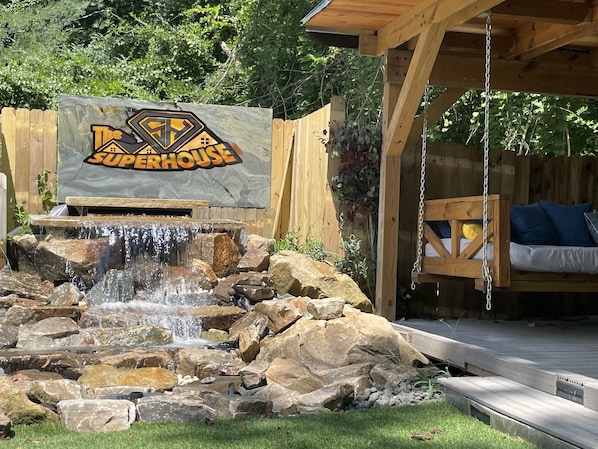 Una terraza de madera con un cartel que dice "The Superhouse".
