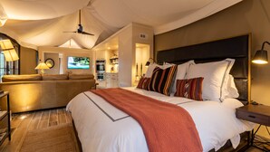 A spacious bedroom with a large bed, a sofa, and a television. - The Nest of Hot Springs (Garland County)