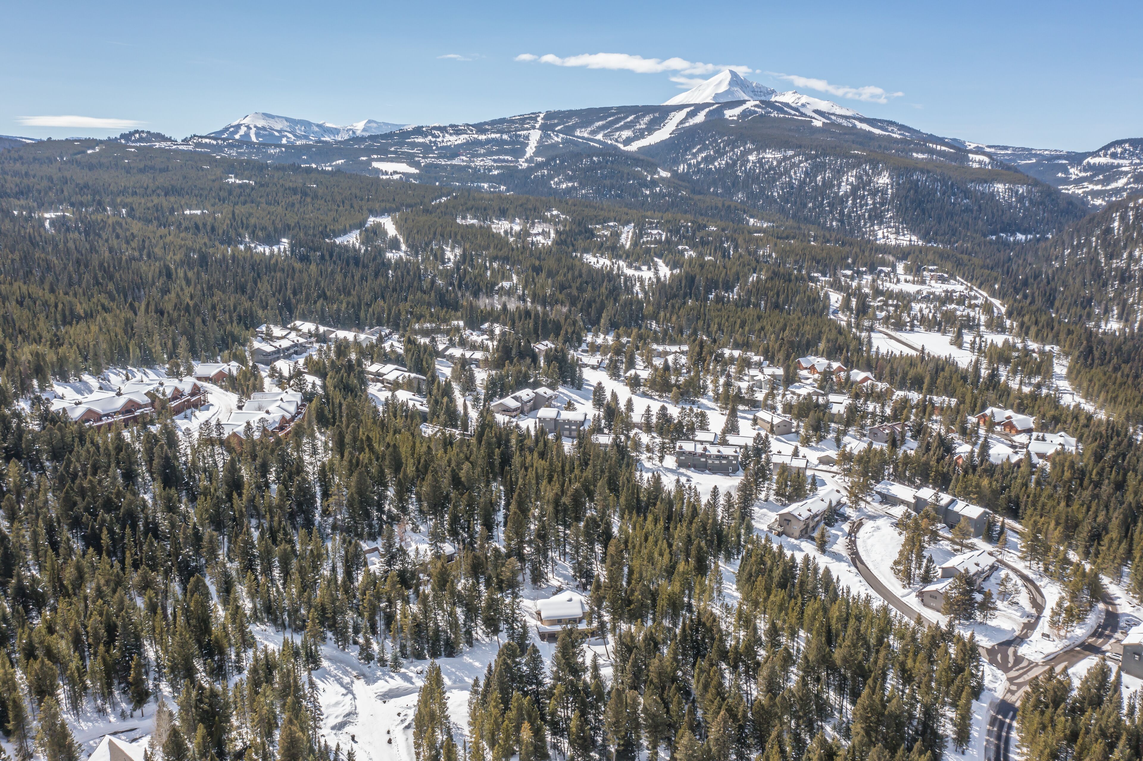Une montagne enneigée, avec une station de ski au premier plan.