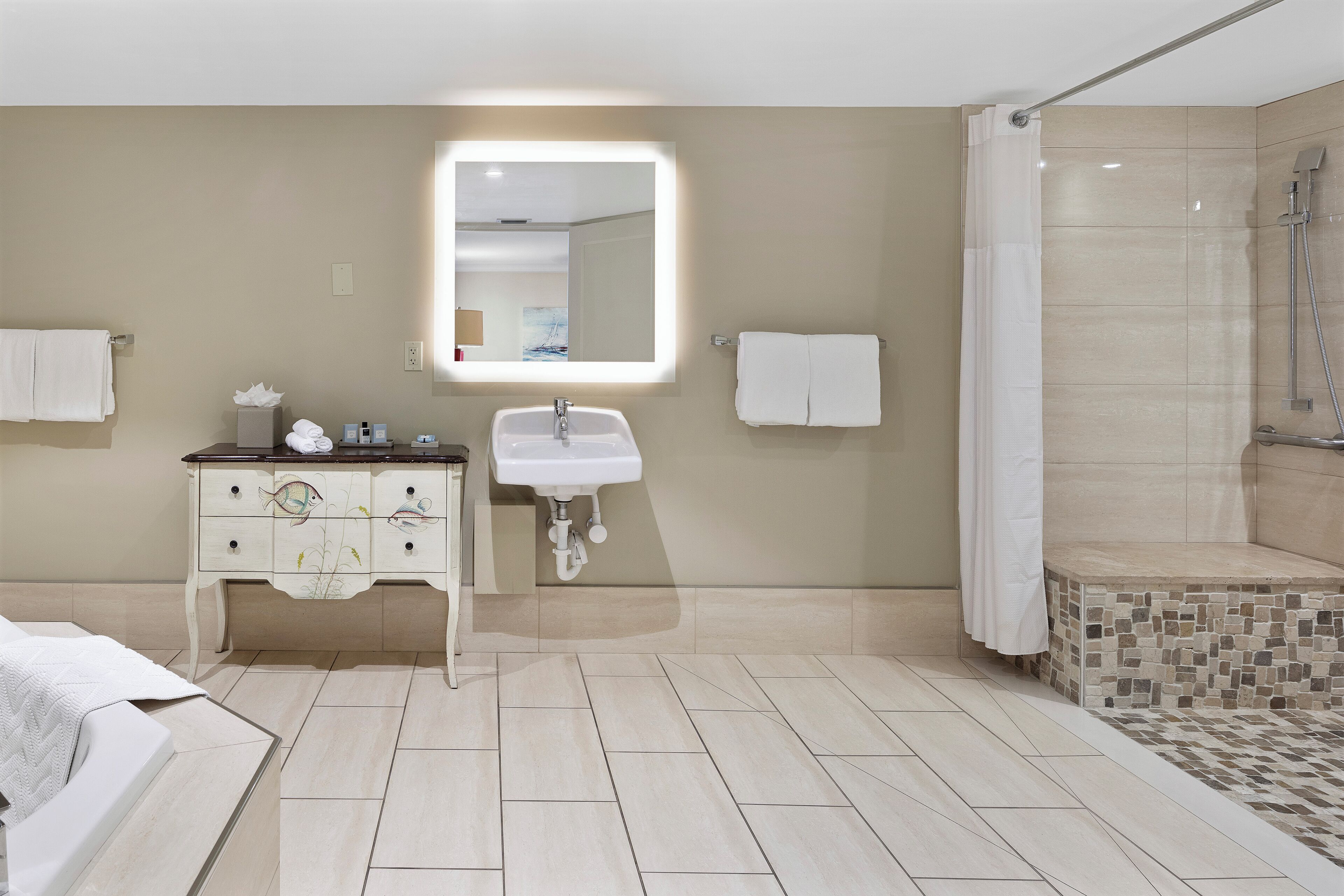 A modern bathroom with a vanity, sink, and shower.