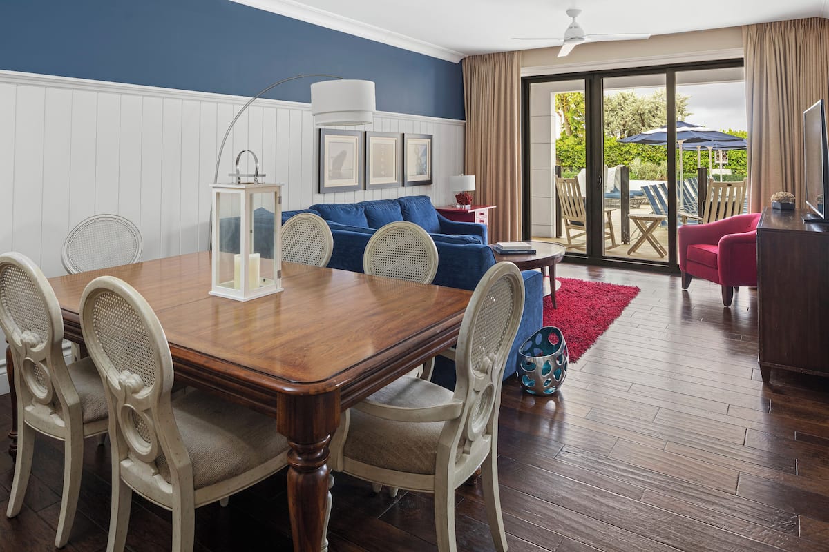 Un comedor con una mesa y sillas de madera, un sofá azul y un sillón rojo.