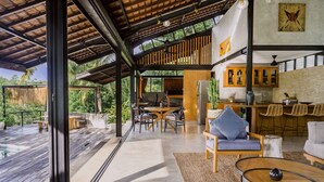 A spacious living area with a wooden deck, a dining area, and a kitchen with wooden cabinets and a large island.
